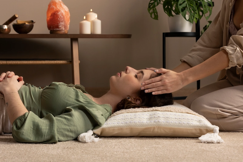 Vrouw ontvangt een ontspannende Thai yoga massage terwijl ze op een kussen ligt.